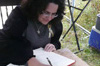 Miranda signing the livre d'or smiling